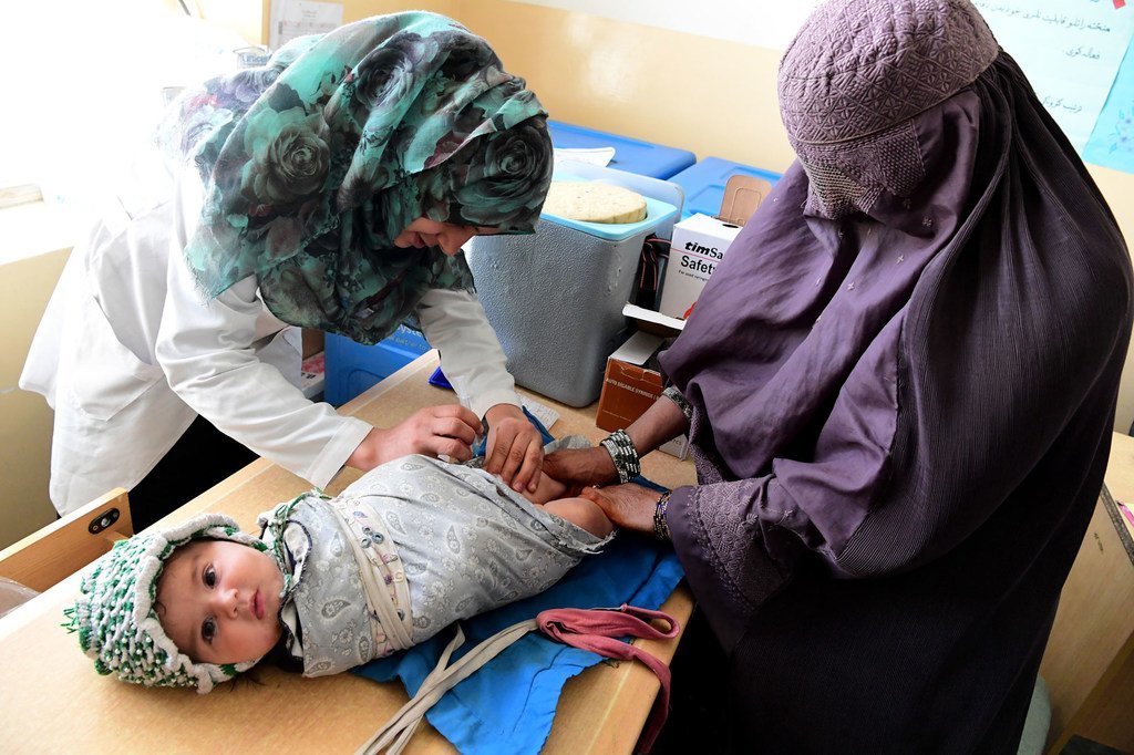 Mother takes her baby to Adam Darmal Clinic in Kandahar, Afghanistan.