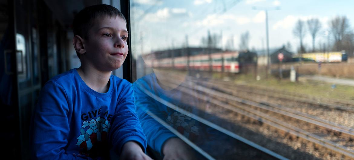 Шестилетний мальчик едет в поезде вдоль польско-украинской границы, спасаясь от конфликта в Украине вместе со своей матерью.