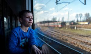 Шестилетний мальчик едет в поезде вдоль польско-украинской границы, спасаясь от конфликта в Украине вместе со своей матерью.