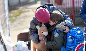 A Ukrainian girl comforts her six-year-old brother as they prepare to leave a UNICEF-supported centre in Romania for their next destination.