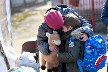 一名乌克兰女孩正在安慰她六岁的弟弟，他们正准备离开位于罗马尼亚的联合国儿童基金会支持的中心前往下一个目的地。