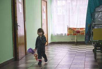 A small child, displaced from an orphanage in the Kharkiv region, walks in the hall of a shelter located in a sanatorium in Vorokhta, western Ukraine.