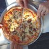 Friends visiting Croatia share a fresh pizza in Makarska, illustrating the importance of food safely to tourism and economic prosperity.