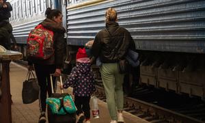 यूक्रेन के लिविफ़ शहर में महिलाएँ और बच्चे सुरक्षित निकासी के लिये ट्रेन में सवार हो रहे हैं.