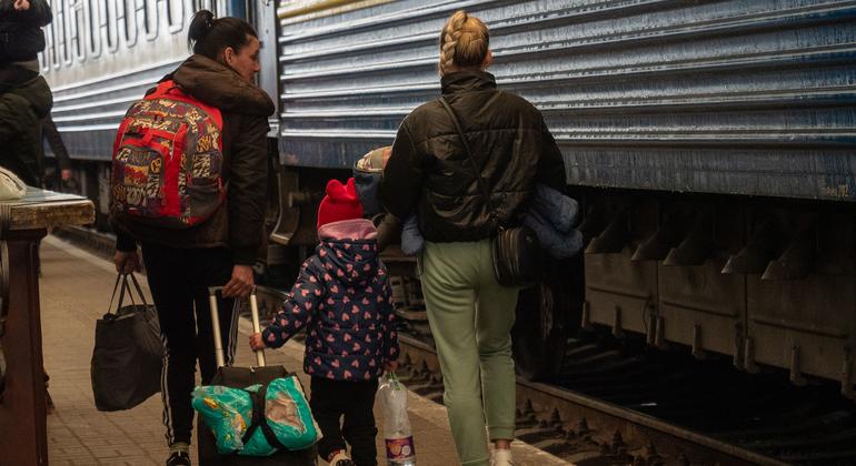 Des femmes et des enfants montent à bord de trains à la gare de Lviv en Ukraine.