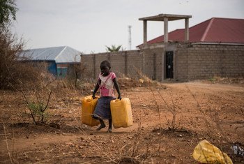 طفل يحمل صفائح مياه فاغة ليملأها من صنبور قريب يوفر مياه غير معالجة من نهر النيل في جوبا، جنوب السودان.