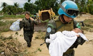 Un Casque bleu brésilien vient au secours d'un enfant, après que des zones de la capitale Port-au-Prince, ont été inondées lors d'une tempête tropicale en 2007.