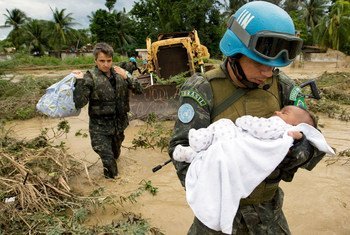 Un miembro brasileño de las fuerzas de mantenimiento de la paz de las Naciones Unidas rescata a un niño después de que partes de la capital de Haití, Puerto Príncipe, se inundaran durante una tormenta tropical en 2007.