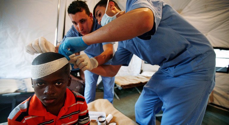 在2010年1月海地大地震后，来自约旦的联合国维持和平人员正在救治一名受伤的男孩。