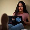 Emily, refugiada venezuelana, usa o computador em sua casa, no Equador 