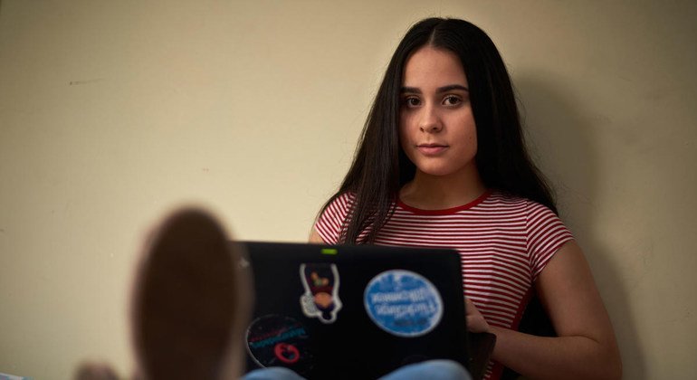 La estudiante refugiada venezolana Emily usa su computadora portátil en Quito, Ecuador.