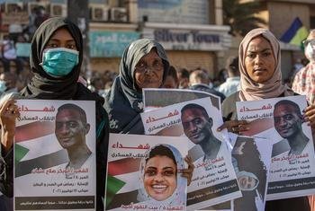 喀土穆的三名妇女手持在苏丹抗议活动中丧生的亲人的照片。