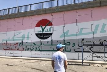 United Nations staff member Brenden Varma in front of a mural commissioned by the United Nations Assistance Mission for Iraq (UNAMI) to urge Iraqi citizens to vote, 15 September 2021.