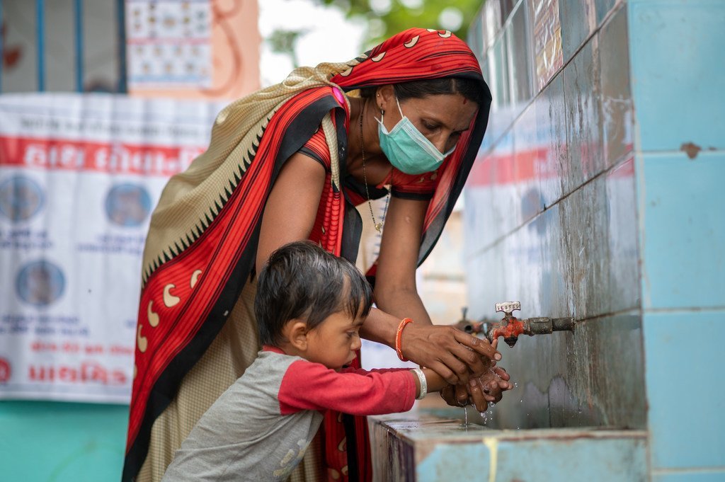 عاملة صحة مجتمعية تشرح لصبي صغير كيفية غسل يديه بشكل صحيح من أجل النظافة والوقاية من فيروس كورونا في غوجارات، الهند