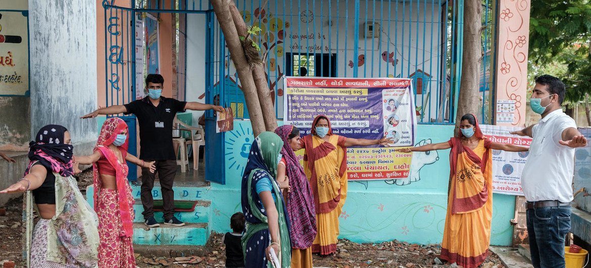 संयुक्त राष्ट्र बाल कोष (यूनीसेफ़) के सलाहकार, डॉक्टर नीरज, भारत के गुजरात में चनोटा फाड़िया, ए-डब्ल्यू बारिया में, ममता दिवस (VHND) के अवसर पर, हाथ साफ़ करने की तकनीक और शारीरिक दूरी का पालन करने के फ़ायदे बताते हुए.