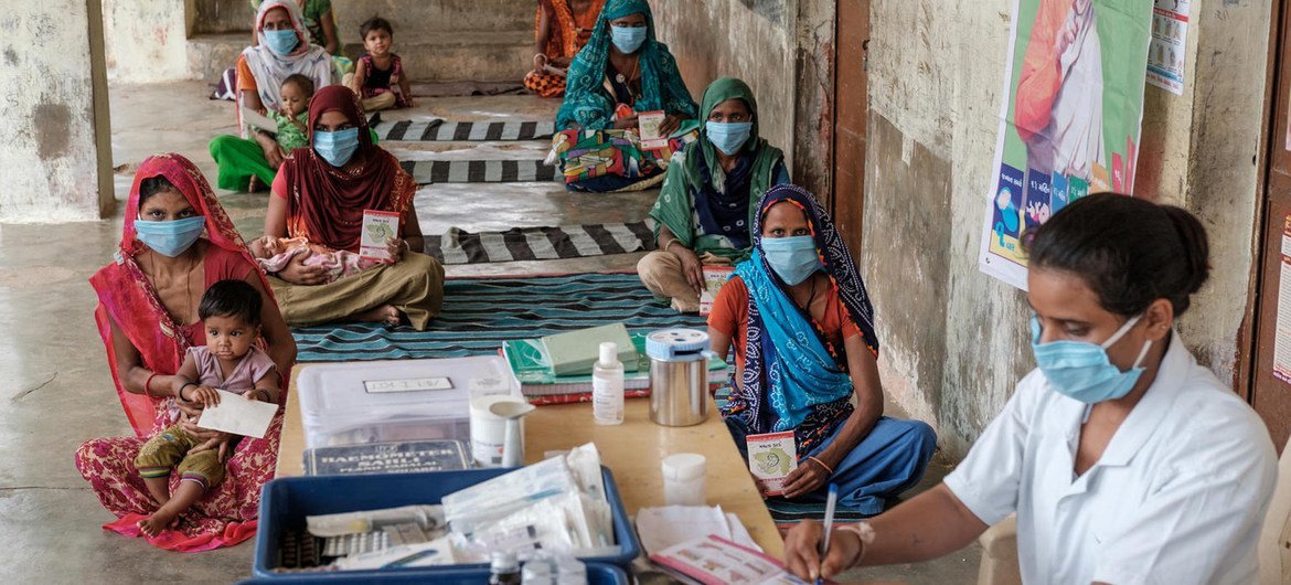 Familia zikipokea chanjo na ushauri katika kijiji walichozingatia umbali unaohitajika cha afya na lishe Gujarat, India.