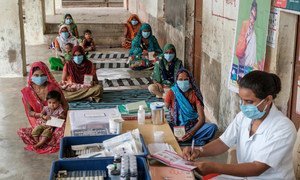 Families receive vaccinations and counselling at a socially distanced Village Health and Nutrition Day in Gujarat, India. 