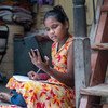 学校因防控新冠疫情而暂时关闭后，一名印度女童在家中使用手持设备进行远程学习。