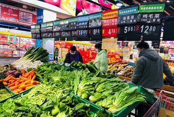 चीन के एक सुपरमार्केट में लोग मास्क पहन कर ख़रीदारी कर रहे हैं. 