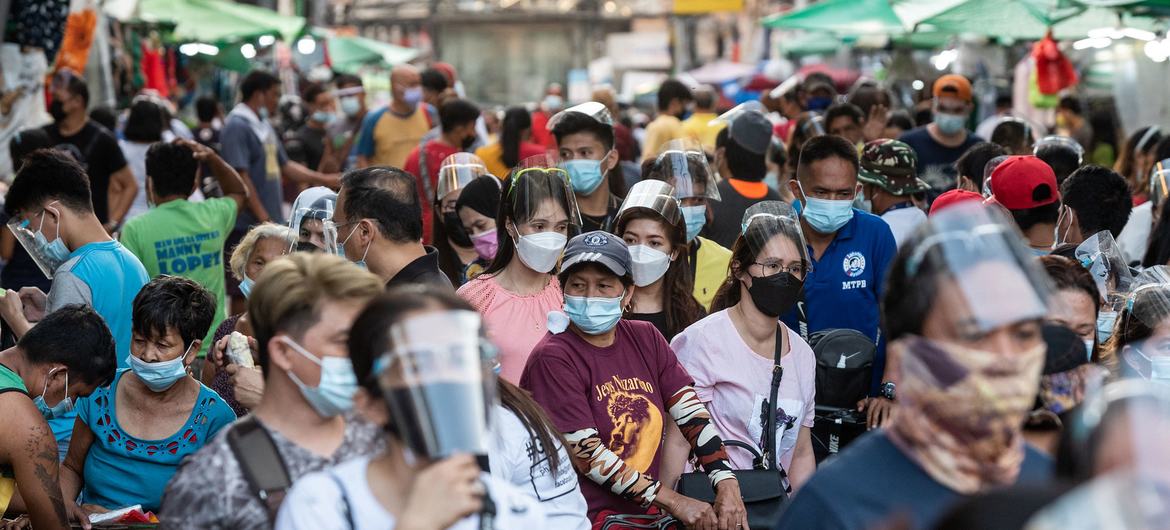 Gente caminando con las mascarillas puestas durante la pandemia de COVID-19 en Quiapo (Filipinas).