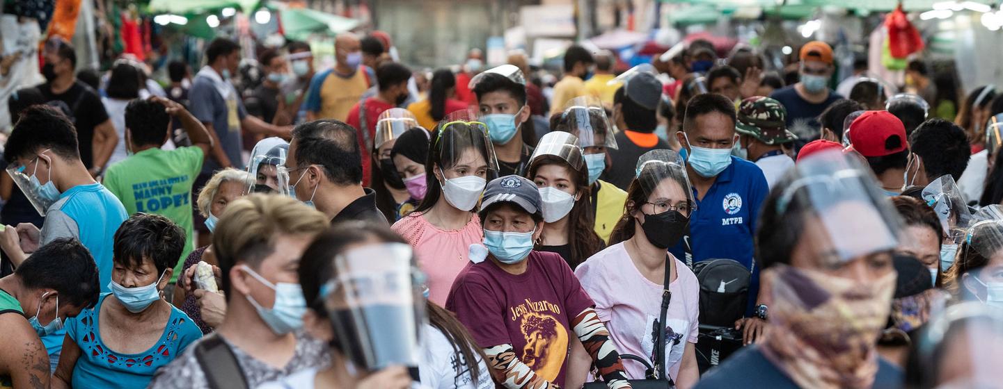 Gente caminando con las mascarillas puestas durante la pandemia de COVID-19 en Quiapo (Filipinas).