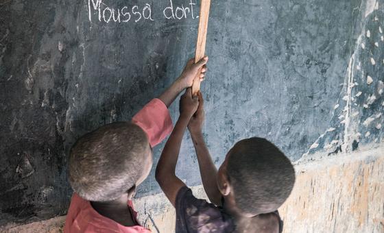 Des élèves écrivent sur un tableau noir dans une salle de classe au Niger.