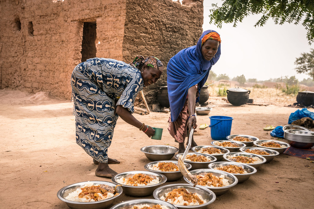 Wazazi wakiweka chakula kwenye sahani tayri kuwapatia wanafunzi shuleni nchini Niger 