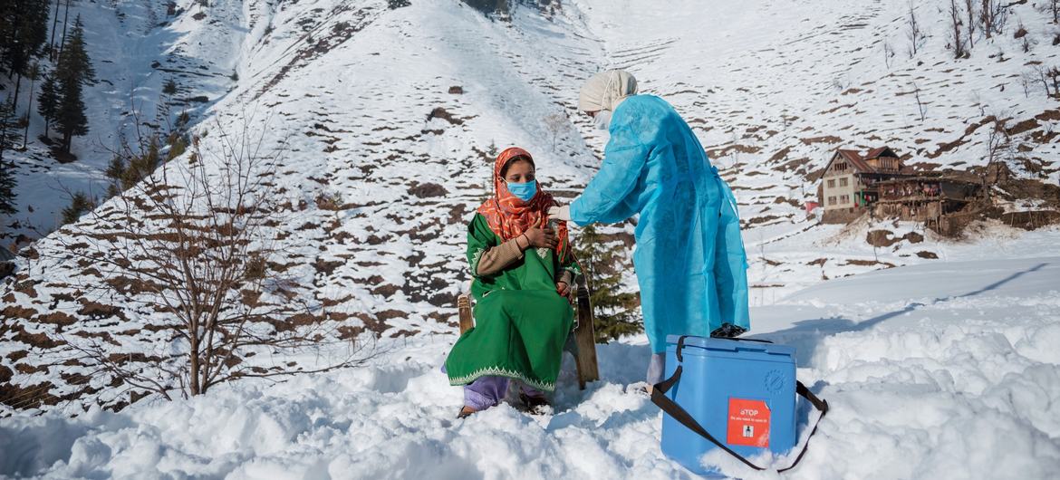Profissional de saúde de uma clínica no norte da Caxemira enfrenta temperaturas congelantes e neve para vacinar pessoas que vivem em áreas remotas da Índia