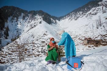 उत्तरी कश्मीर में एक स्वास्थ्यकर्मी, कंपकपाती ठण्ड और बर्फ़बारी का सामना करते हुए, भारत के दूरदराज़ के इलाक़ों के लोगों को टीका लगा रही हैं.