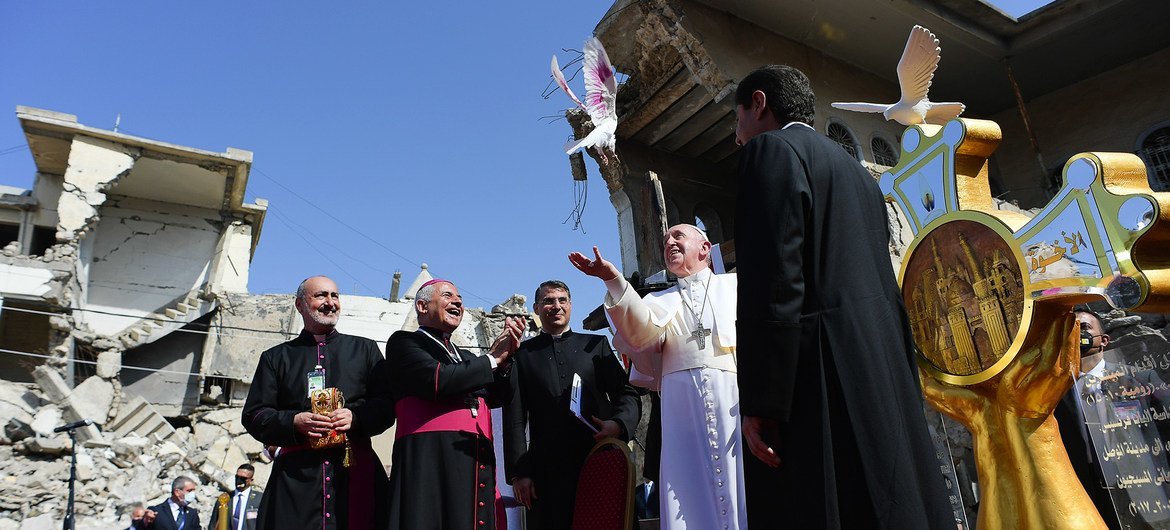 पोप फ्रांसिस (मध्य) इराक़ के मोसुल में, एक चर्च के ध्वस्थ स्थल पर शान्ति के प्रतीक कबूतर को उड़ाते हुए.