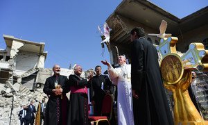教皇方济各（中）在伊拉克摩苏尔的叙利亚天主教堂废墟上放飞一只代表和平的鸽子。