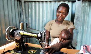 Una madre trabaja de sastre mientras cuida a su bebé en Suba, Kenia.