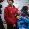 在罗马尼亚的伊萨卡，一位母亲在等待交通工具时安慰她7岁的儿子。