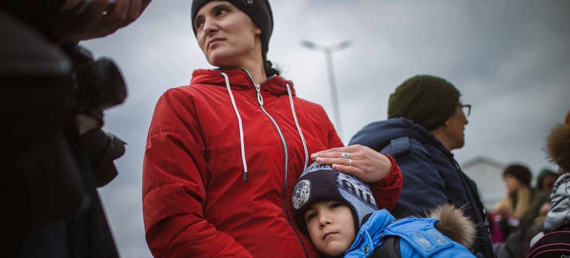 A Ukrainian mother comforts her seven-year-old son, while waiting for a means of transportation in Isaccea, Romania.
