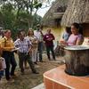Dulce Cruz muestra una estufa que ahorra leña a un grupo de personas en un entorno rural de México.