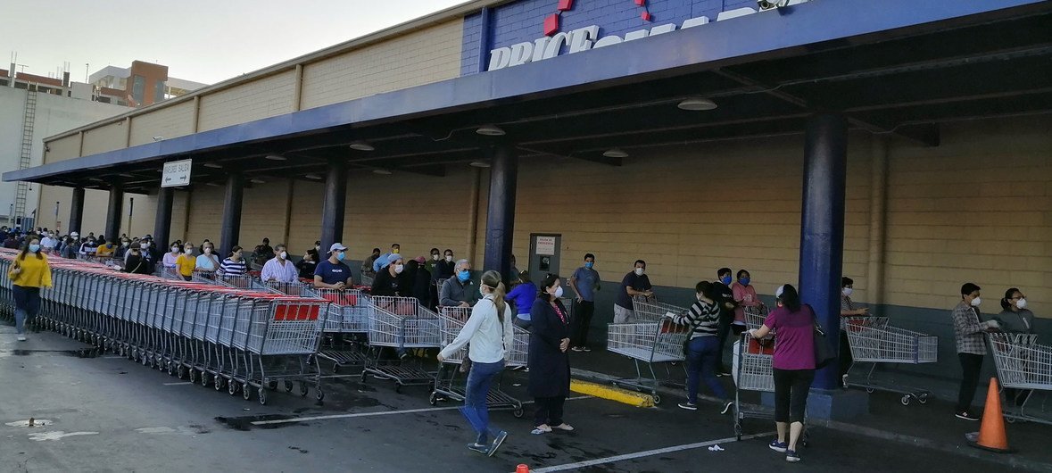 Guatemaltecos hacen fila para entrar al supermercado como parte de las medidas de prevención del coronavirus.