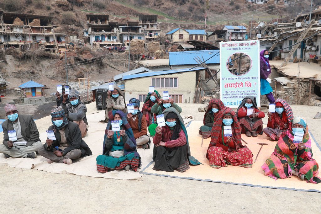 Les personnes âgées d'un village reculé du Népal brandissent leur carte de vaccination après avoir reçu des vaccins contre la Covid-19.