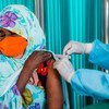 Une réfugiée au Rwanda reçoit sa première injection du vaccin contre la Covid-19.