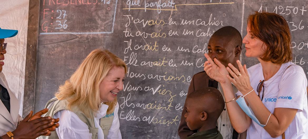  Mkurugenzi Mtendaji wa UNICEF Catherine Russell akitangamana na mwanafunzi katika darasa la muda lililojengwa katika kambi ya Rhoe mashariki mwa DRC.