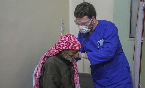 A doctor checks a patient displaced by conflict in Syria.   