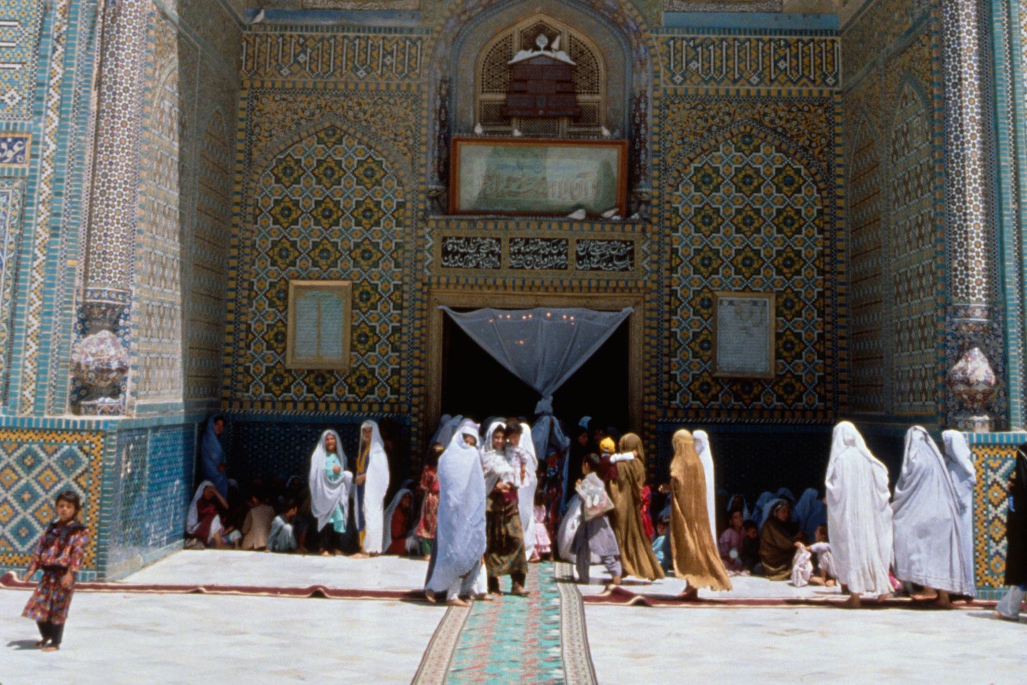 Women gather in the shade of the high archway entrance to a mosque in the northern city of Mazar-i-Sharif, Afghanistan.