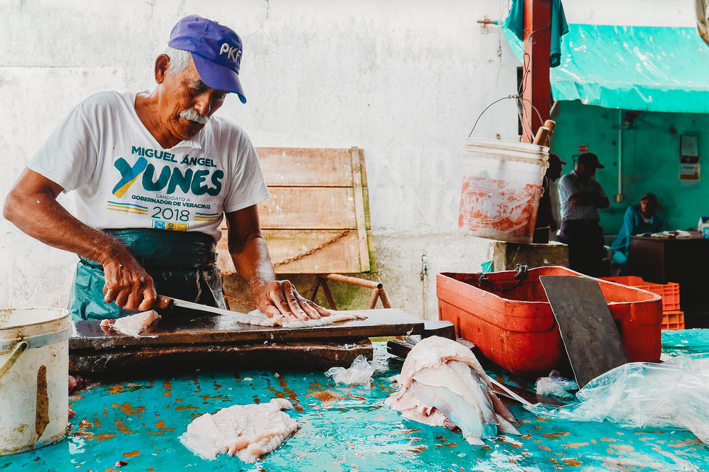 Un vendedor limpia el pescado, en Alvarado, Veracruz (México).