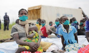 Une demandeuse d'asile de 29 ans, originaire de la République démocratique du Congo, est assise avec ses enfants après avoir subi un examen médical près du poste frontière de Zombo, en Ouganda.