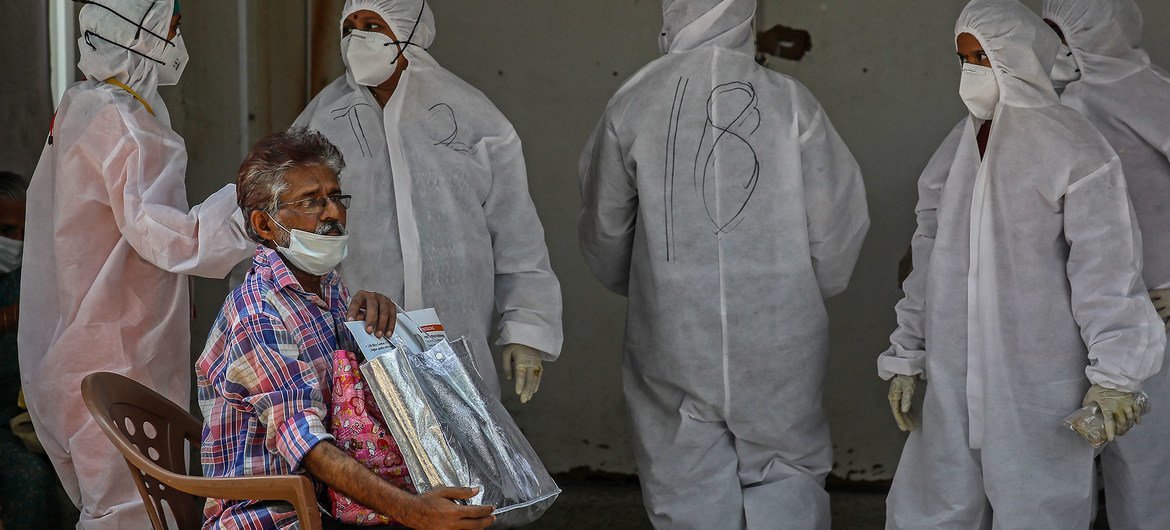 Homem espera para ser testado para Covid, do lado de fora de um hospital em Mumbai, na Índia