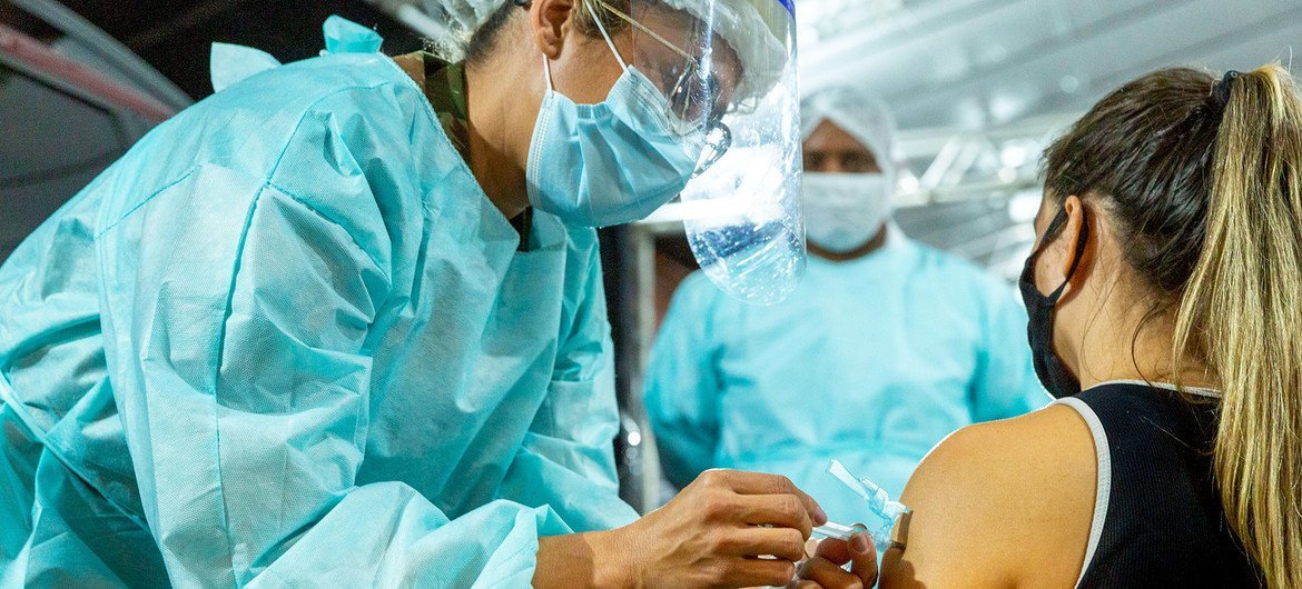 A Brazilian health worker receives a COVID-19 vaccination.