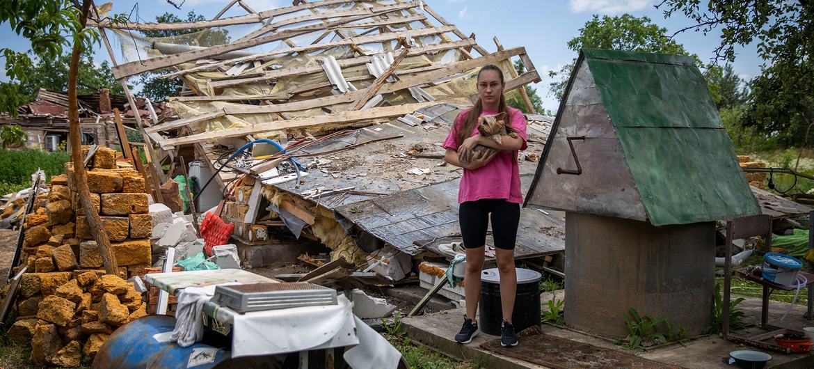 Svitlana, 24 ans, pose devant sa maison détruite à Nalyvaikivka, en Ukraine. Sa famille a eu la vie sauve lorsque sa maison a été complètement détruite par deux missiles.
