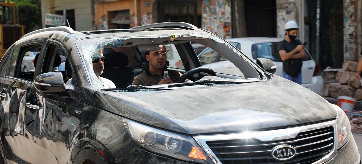 رجل يقود مركبة بلا زجاج أمامي تضررت بسبب انفجار بيروت يوم الثلاثاء.