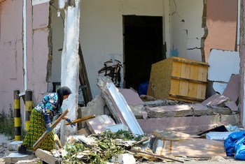Una mujer busca algo que le pueda servir en los escombros de su casa destruida por la explosión en Beirut.