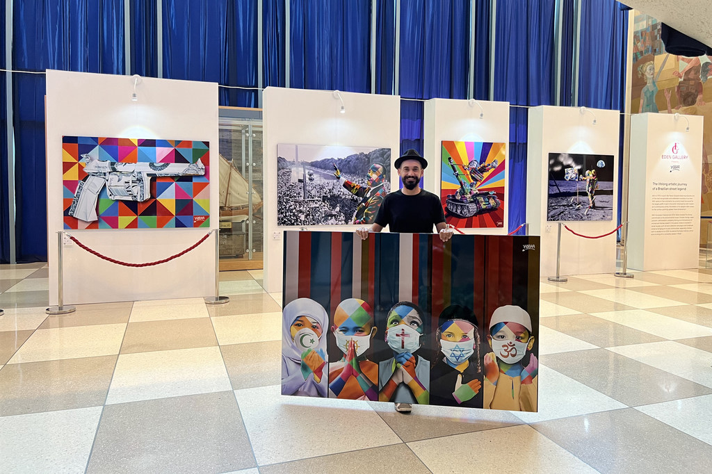 Eduardo Kobra junto a algunas de sus obras en una exposición de 2022 en la sede de la ONU.