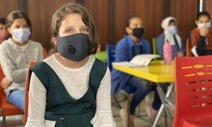 Crianças se protegem da Covid-19 usando máscaras na sala de aula. 